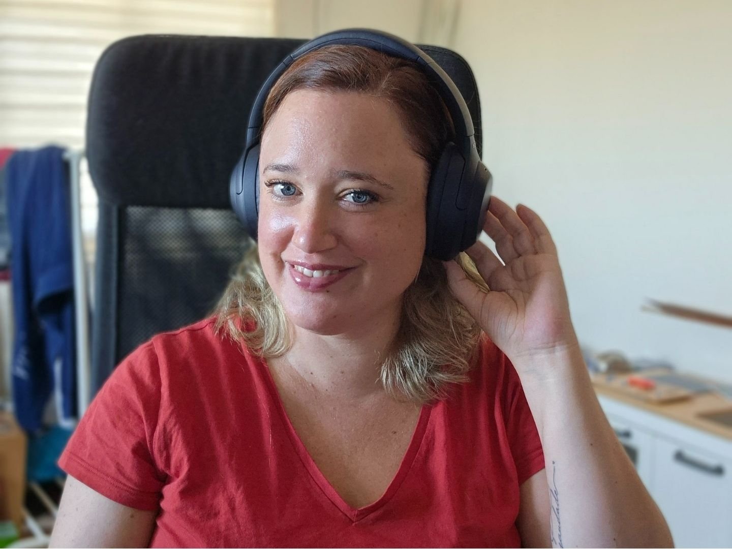 Specialist klantbeleving Linda Lubbers zit achter het bureau met een koptelefoon op