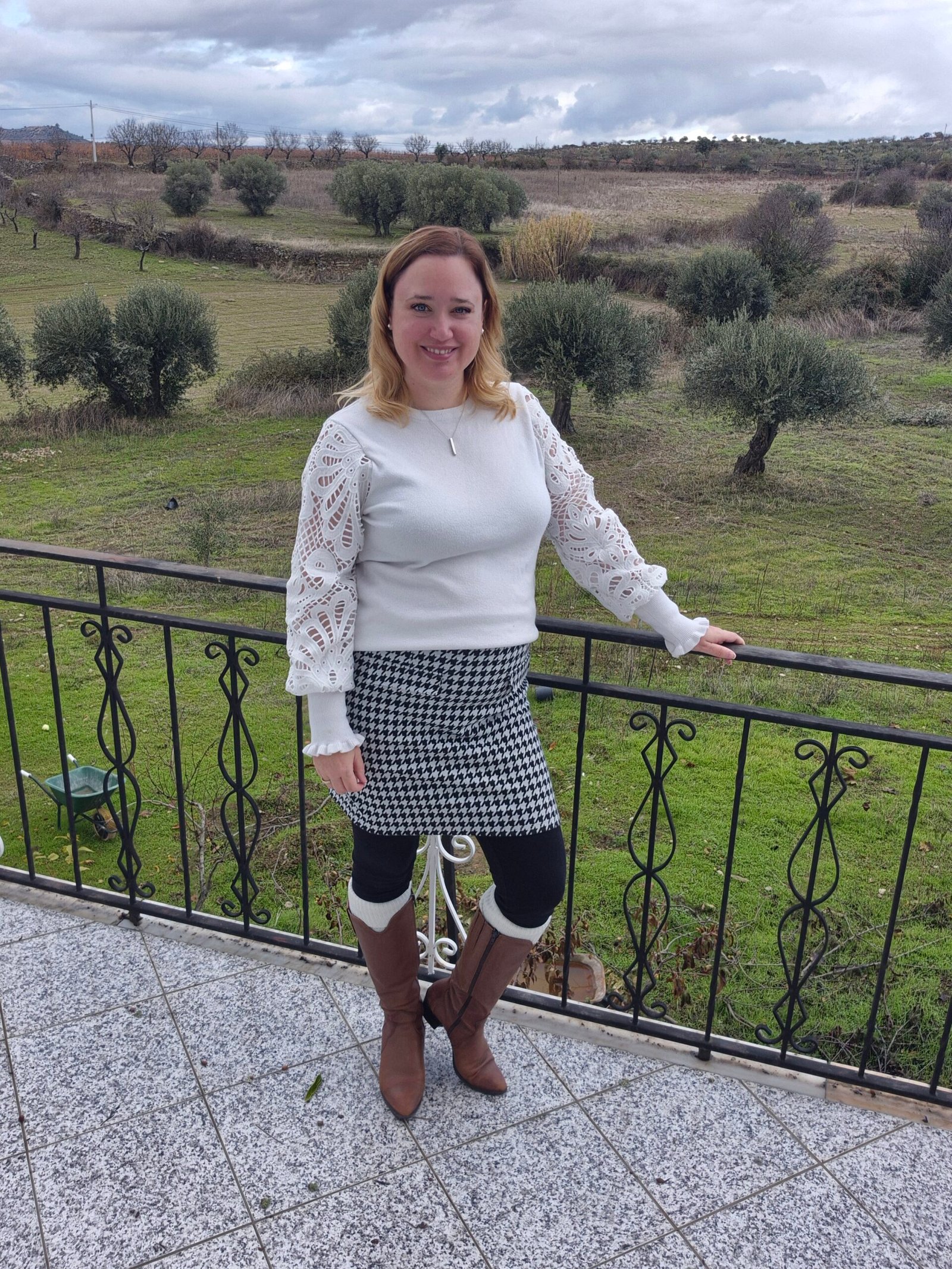 Linda Lubbers, specialist klantbeleving, in portugal staat op het balkon van haar huis.